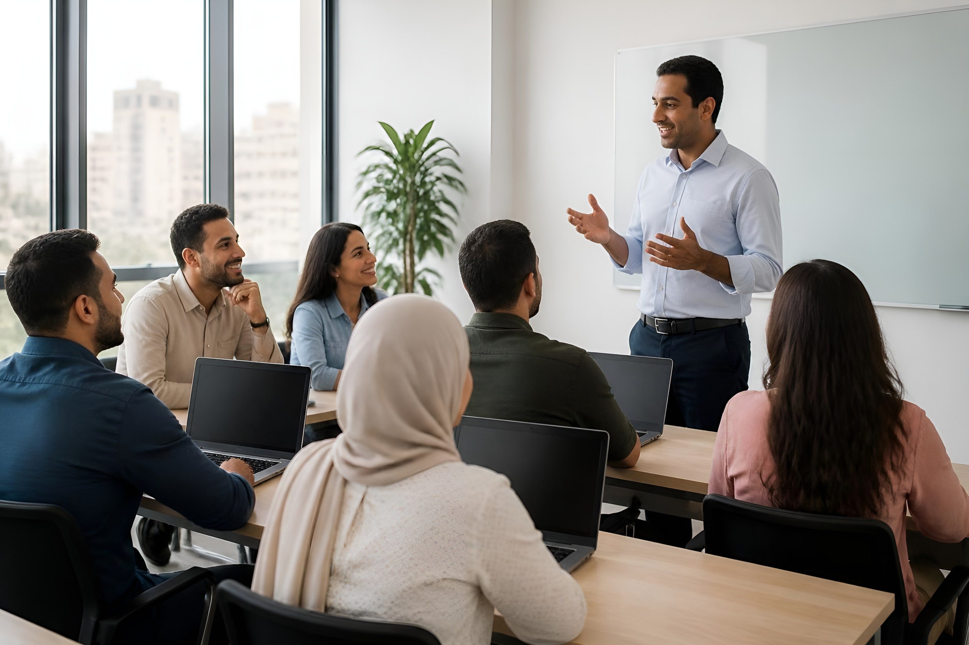 Trainer leading a class of adults working on laptops